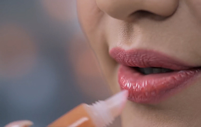 Maquillaje de labios coral con efecto gloss